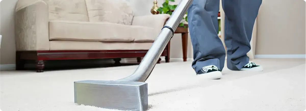 Carpet cleaning technician using a hot-water extraction wand on a light-colored carpet in a living room, Cape Coral, FL.
