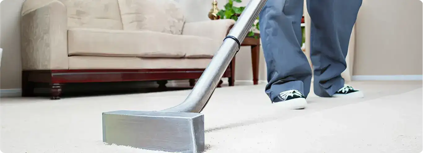Carpet cleaning technician using a hot-water extraction wand on a light-colored carpet in a living room, Cape Coral, FL.
