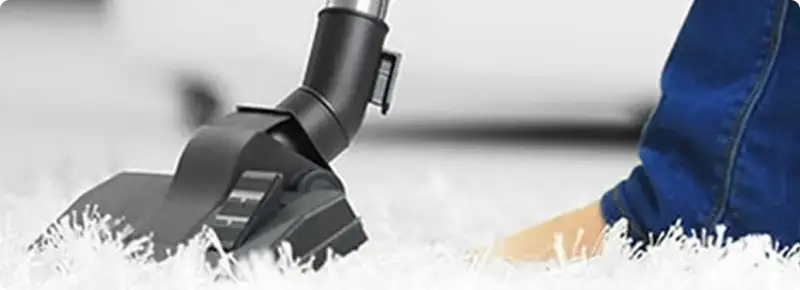 Close-up of a professional vacuuming a white carpet in Sanibel.